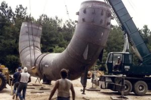 Big black pipe being held up by a construction car